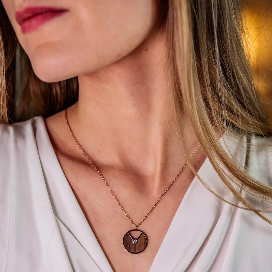 Rosegoldene Halskette mit Walnussholz und Kristall für Damen mit weißem Oberteil getragen